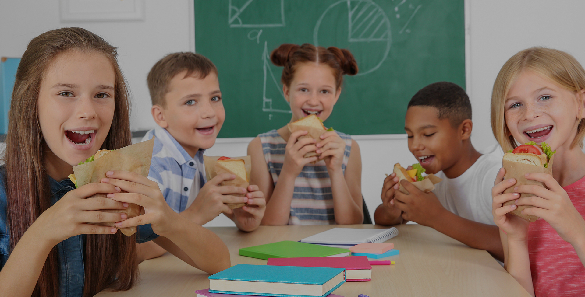 schoolchildren having lunch in classroom