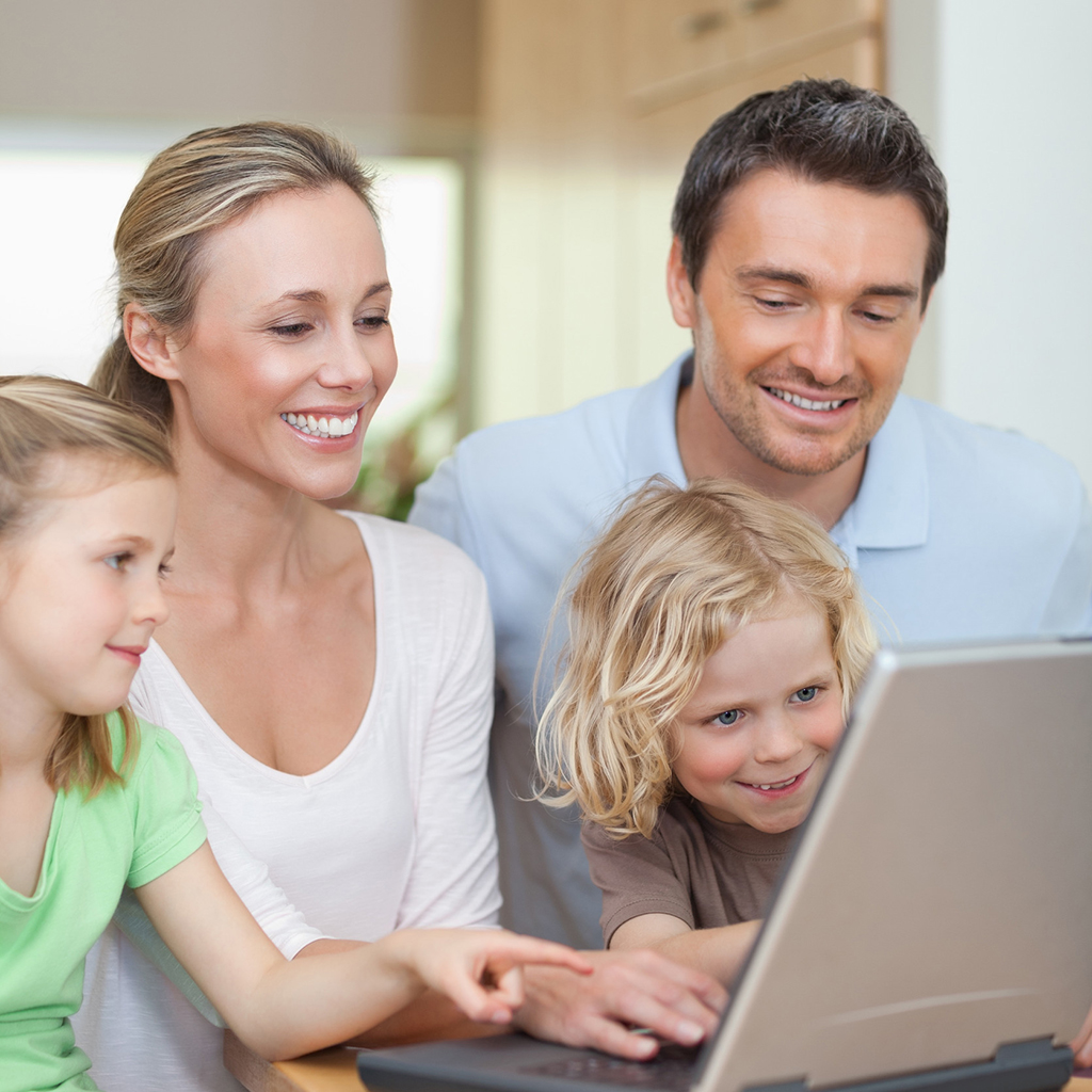 family using laptop in the kitchen together