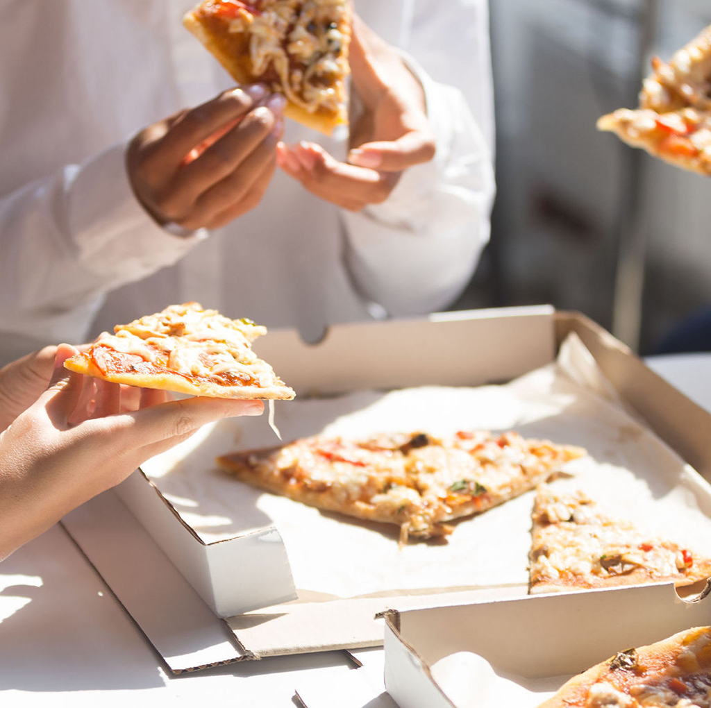 close up business people eating pizza during lunch
