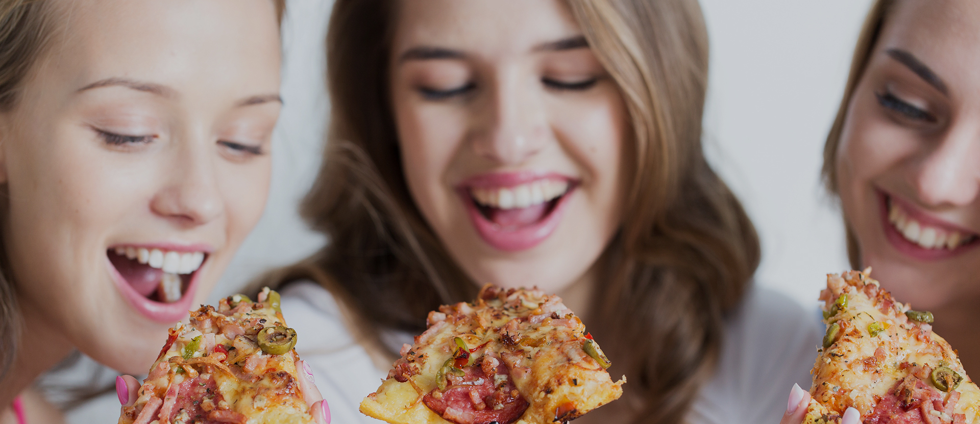 happy friends or teen girls eating pizza at home